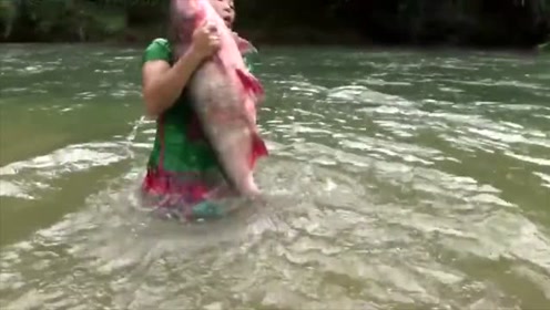 美女飞扑下河,抓到一个半人高的鱼,这下可以吃个饱了!
