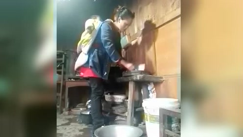 大山里的媳妇背着孩子做饭,看着让人心酸