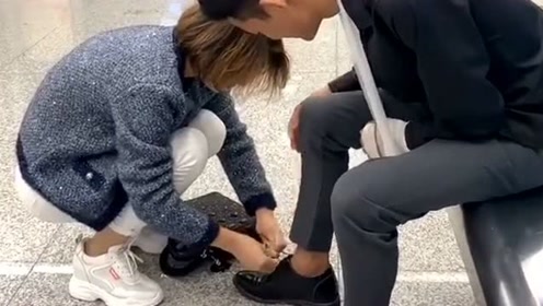 弘扬正义传播正能量,伤残小伙系鞋带很乏力,一位善良的小姐姐蹲下送