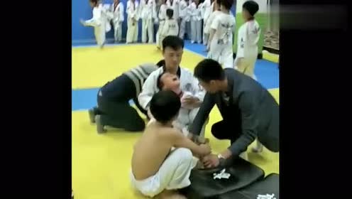 这个跆拳道教练是个狠人,竟然这样给小男孩压腿,看着就很疼!